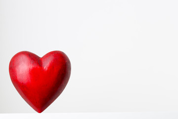Red heart on the gray metal background.