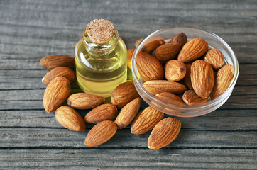 Almonds seed and almond oil on old wooden background for beauty spa and treatment.Selective focus.
