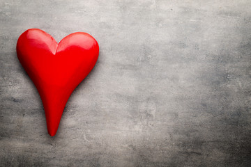 Red heart on the gray metal background.