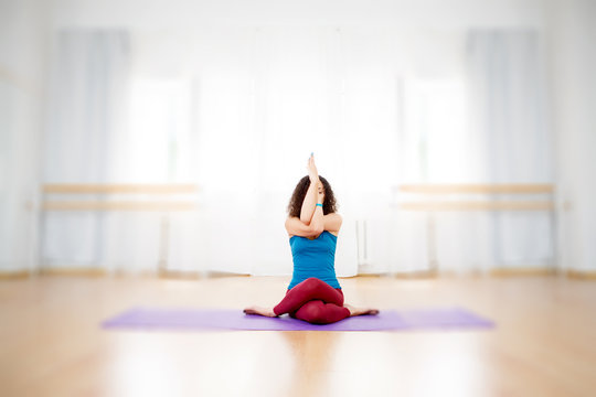 Young fit woman practicing yoga asana garudasana