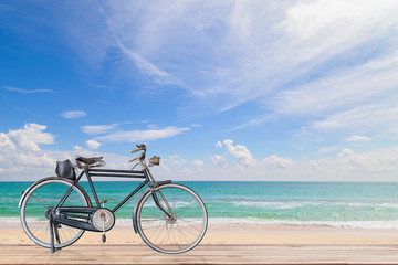 Fototapeta na wymiar Old bicycle on wood with Turquoise sea , beautiful sea beach a