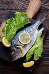 Baked sea bream served with fresh green salad and lemon