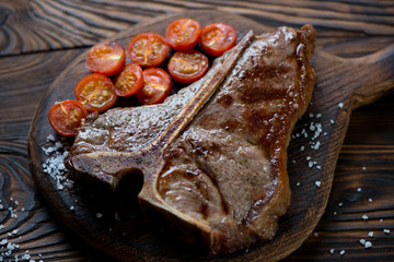 Grilled marbled beef T-bone steak with baked cherry tomatoes