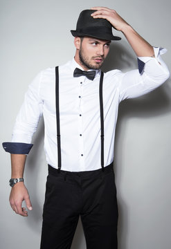 handsome young man wearing hat, suspenders, bow tie and a watch
