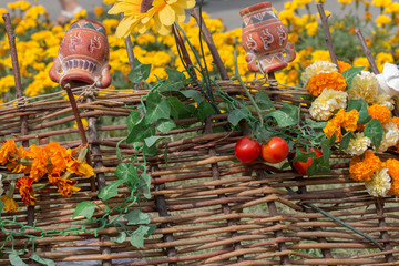 clay jugs are hanging on a wicker fence