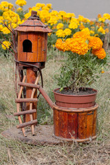 wooden birdhouse next to the flowers in the garden