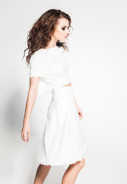 beautiful woman model posing in white dress in the studio