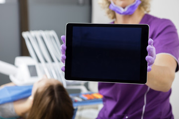 Midsection Of Dentist Showing Tablet Computer With Blank Screen