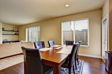 Dining area with wooden table set and leather chairs.