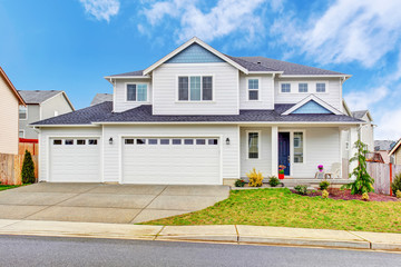 Luxury two level house exterior with garage and concrete driveway.