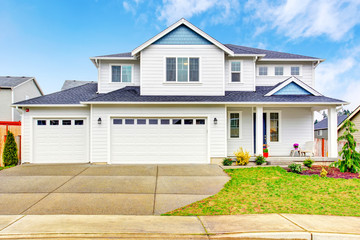 Luxury two level house exterior with garage and concrete driveway.