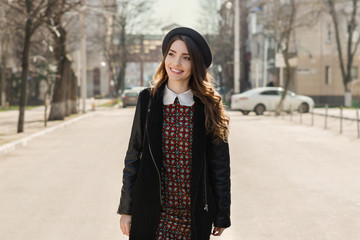 Beautiful brunette girl in stylish dress posing on the city street