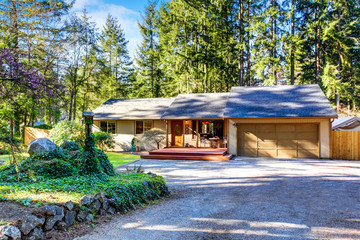 Grey house with wooden trim and gravel walkway. Curb appeal