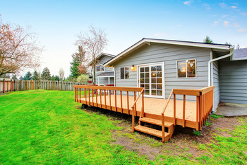 Two story house with wooden walkout deck. Fenced backyard
