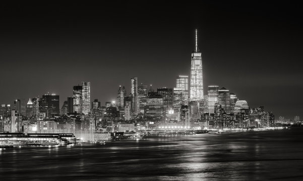 Skyscrapers of New York City Financial District illuminated at night. Aerial panoramic view of Lower Manhattan and the Hudson River in Black & White