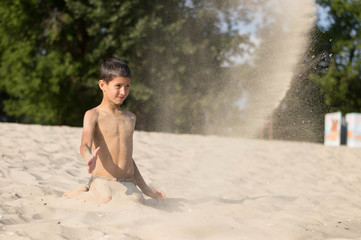 a boy plays on the beach