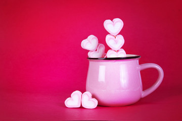 the marshmallow heart shape in cup on pink background with love
