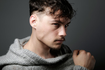 Handsome young man looking at camera. Isolated on grey.