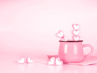 marshmallow heart shape in cup on pink background with love conc