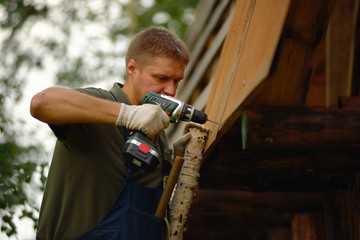 Builder or carpenter working and builds a roof