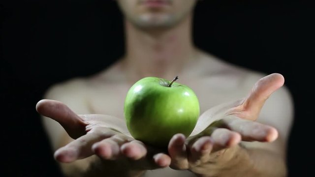 A man's hands holding an apple