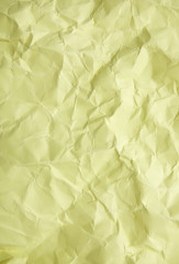 A full page of scrunched up pastel yellow wrapping paper texture