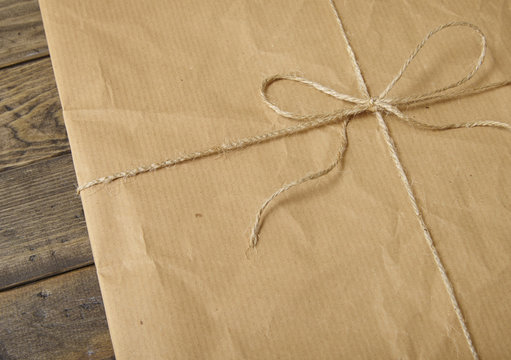 A parcel wrapped in brown wrapping paper and tied up with string bow