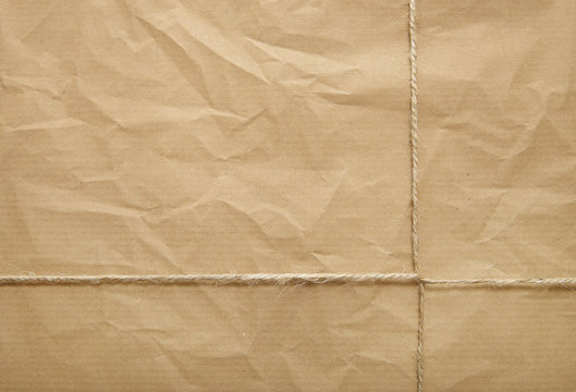 A Full Page Of Creased Brown Package Paper Texture With Twine Tied Around It