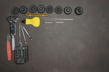 watchmaker tools on leather background