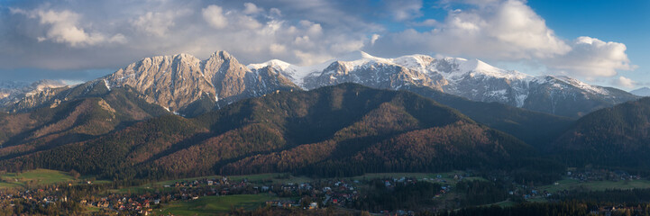 Panorama of snow-capped High Tatras on the Polish side, with a beautiful cloudy sky and a view of the city of Zakopane with many interesting details - obrazy, fototapety, plakaty