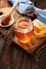 Honey in jar and bunch of dry lavender