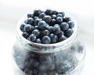 Blueberries in glass jar on a white background