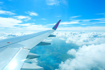 Obraz premium Airplane flying above clouds and sunrise