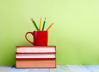 Fototapeta premium Stack of hardback books, diary on wooden deck table and green background. Back to school. Copy Space. Education background