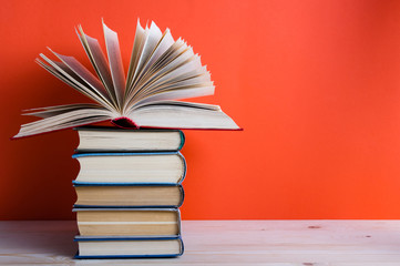 Open hardback book on wooden deck table and red background