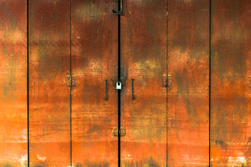 Red iron door with a padlock to lock.