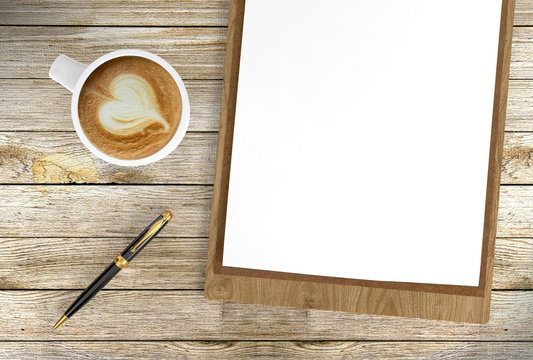 Cappuccino coffee cup with blank papers on clipboard and ballpoint pen on wooden background, coffee and business background