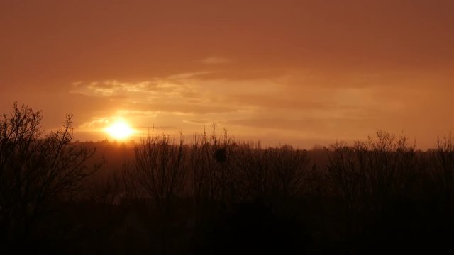 Big golden sun sunset over the city on the north of Europe 4K 2160p 30fps UltraHD tilting video - Slow tilt while sun goes down behind hills 4K 3840X2160 UHD footage 