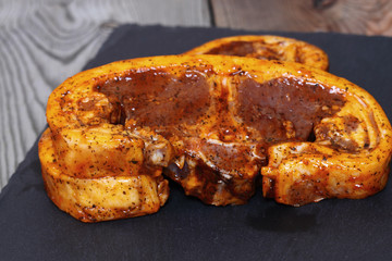 Raw lamb chops with a mint sauce marinade on slate