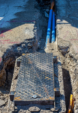 fiber optic cables buried in a micro trench with concrete colored red by a worker