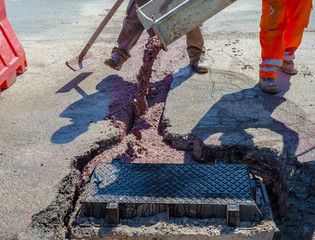 fiber optic cables buried in a micro trench with concrete colored red by a worker
