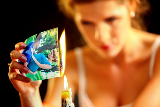 Uhappy girl burn love photos. Love is gone. Model on photo is the same image in the picture.