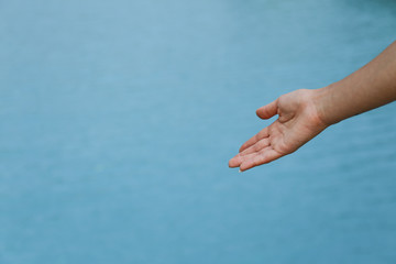 Woman hand point at blue lake