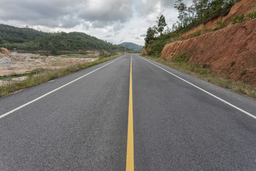 asphalt road and mountain forest area.