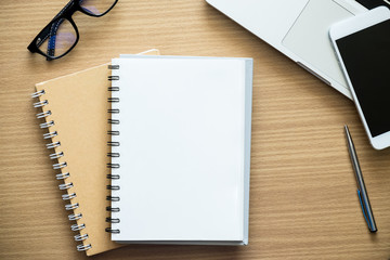 Workplace. Empty notepad, laptop and smart phone on wooden table