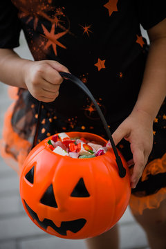 Girl with pimpkin bag with candies