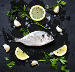 Fresh Fish Orata Over a Black stone with vegetables