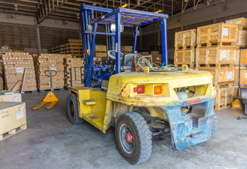 Fototapeta na wymiar Old forklift vehicle used in industrial warehouse for lifting and moving heavy materials. It is also called lift or fork truck.