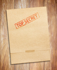  envelope with top secret stamp and papers, on wooden table