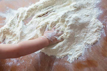 Child's hands playing with the flour